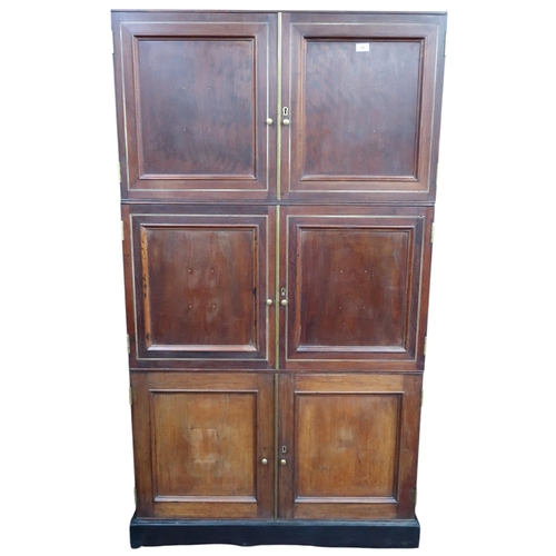 10 - A late 19th century stained teak sectional office cabinet with three pairs of panel doors on plinth ... 