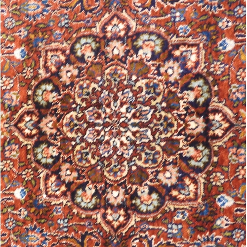 35 - A red ground Isfahan Kashmiri rug with multicoloured central medallion and matching spandrels on ext... 