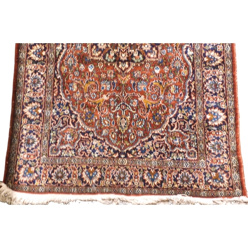 35 - A red ground Isfahan Kashmiri rug with multicoloured central medallion and matching spandrels on ext... 