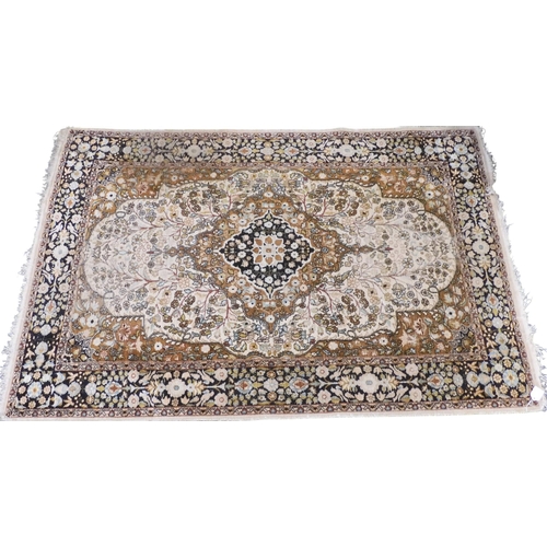 38 - A cream ground Keshan rug with earth tone central medallion and matching spandrels on floral pattern... 