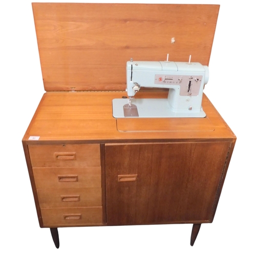 43 - A mid 20th century teak cased Singer sewing machine with four short drawers on tapering supports, 10... 