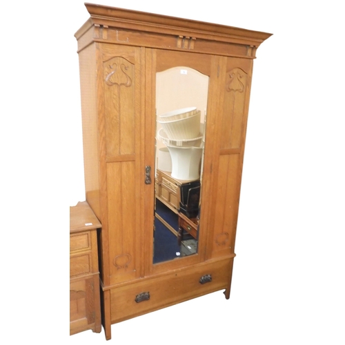 53 - An early 20th century oak Arts & Crafts wardrobe with moulded cornice over single bevelled glass... 