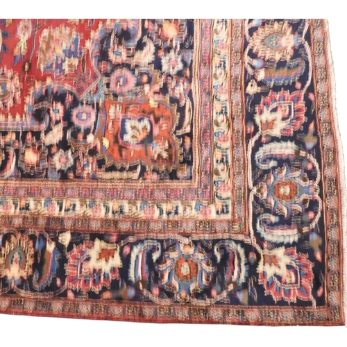 6 - A red ground Mashed rug with dark blue central medallion and matching spandrels on floral patterned ... 