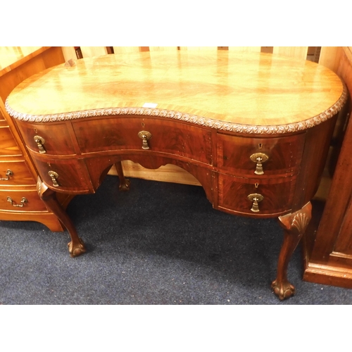 77 - A 20th century mahogany kidney shaped desk with long central drawer flanked by pairs of short drawer... 