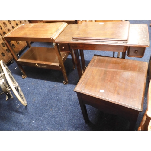 88 - A lot comprising a mahogany cased treadle sewing machine, metamorphic tea trolley and a square toppe... 