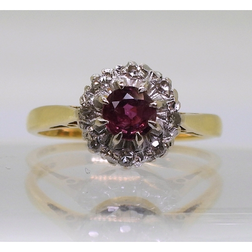 2723 - A RETRO CLUSTER RINGset with a central 4.9mm round cut ruby, surrounded with diamond accents to the ... 