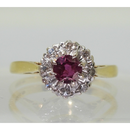 2723 - A RETRO CLUSTER RINGset with a central 4.9mm round cut ruby, surrounded with diamond accents to the ... 