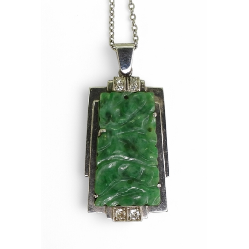 2729 - AN ART DECO PENDANT set with four diamonds and a carved green hardstone panel, length including the ... 