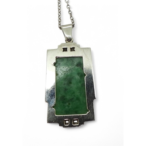 2729 - AN ART DECO PENDANT set with four diamonds and a carved green hardstone panel, length including the ... 