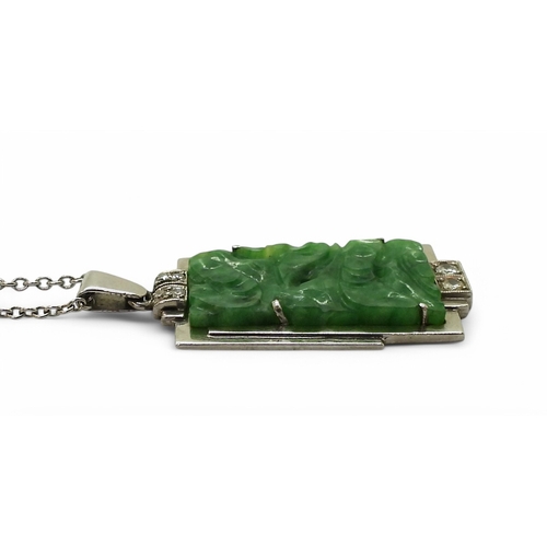 2729 - AN ART DECO PENDANT set with four diamonds and a carved green hardstone panel, length including the ... 