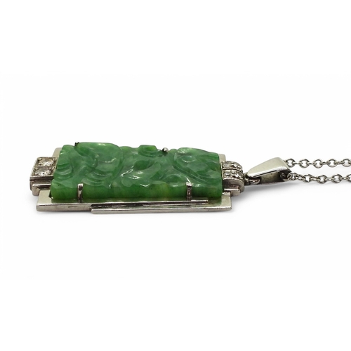 2729 - AN ART DECO PENDANT set with four diamonds and a carved green hardstone panel, length including the ... 