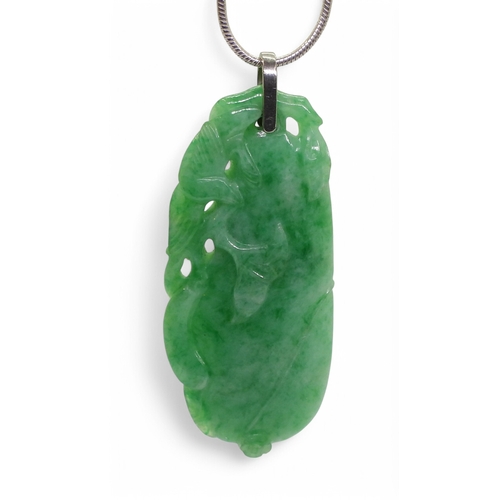 2732 - A CHINESE GREEN HARDSTONE PENDANTcarved with a fruit and a little bird, it has a white metal bail an... 