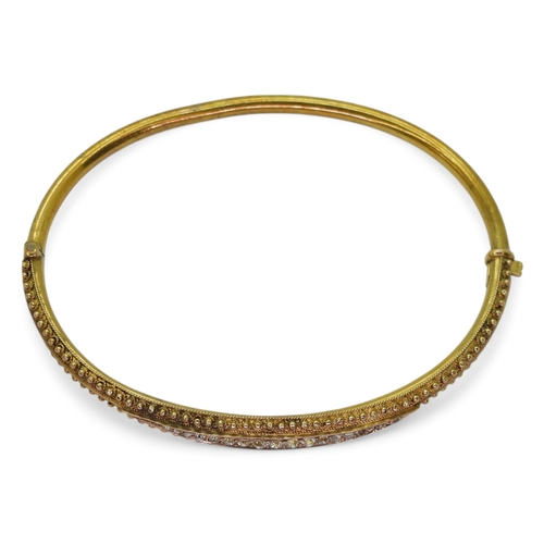 2743 - AN ETRUSCAN REVIVAL BANGLEmade in 15ct gold with wirework and granulation detail the centre set with... 