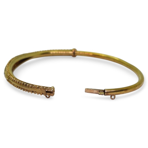 2743 - AN ETRUSCAN REVIVAL BANGLEmade in 15ct gold with wirework and granulation detail the centre set with... 