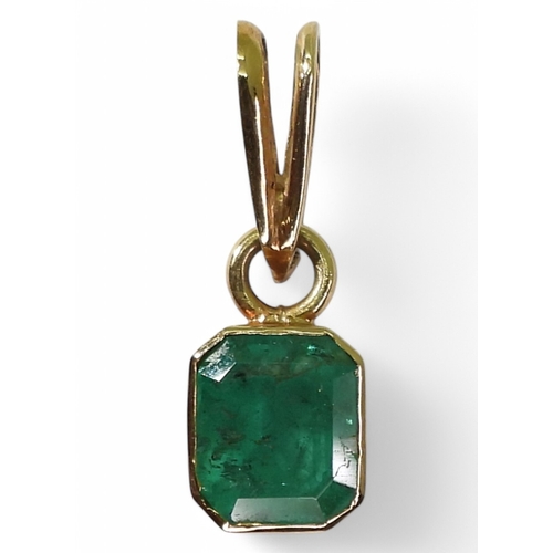 2750 - EMERALD PENDANTA bright yellow metal mounted emerald pendant. Set with a step cut emerald of estimat... 