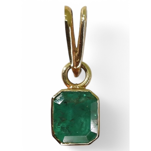 2750 - EMERALD PENDANTA bright yellow metal mounted emerald pendant. Set with a step cut emerald of estimat... 