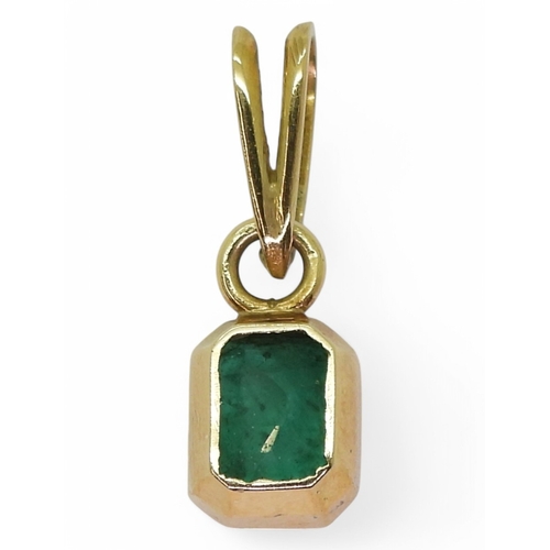 2750 - EMERALD PENDANTA bright yellow metal mounted emerald pendant. Set with a step cut emerald of estimat... 