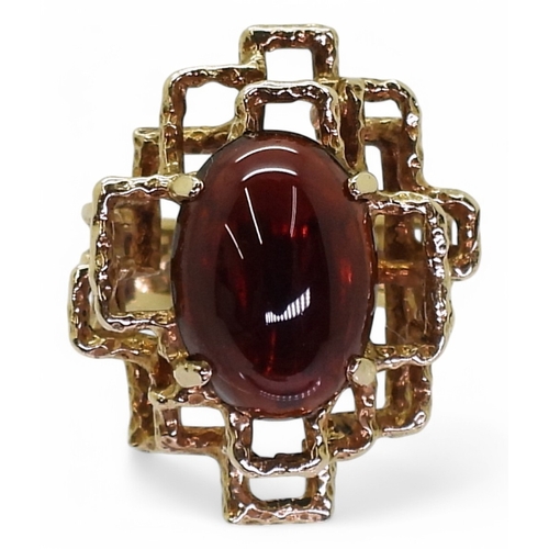 2755 - A RETRO GARNET RINGset with an oval garnet cabochon of approx 14mm x 10mm x 4.5mm, the ring has full... 