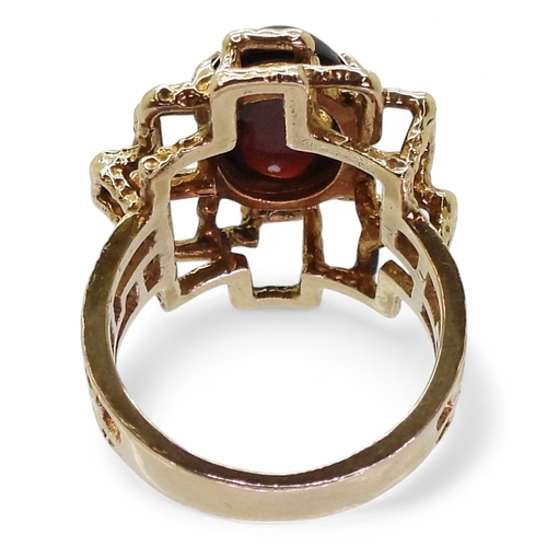 2755 - A RETRO GARNET RINGset with an oval garnet cabochon of approx 14mm x 10mm x 4.5mm, the ring has full... 