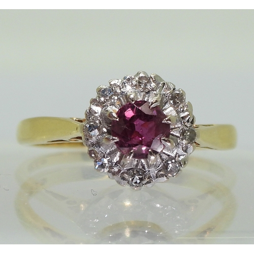 2723 - A RETRO CLUSTER RINGset with a central 4.9mm round cut ruby, surrounded with diamond accents to the ... 