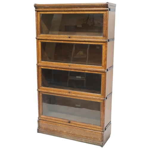 2051 - AN EARLY 20TH CENTURY OAK GLOBE WERNICKE SECTIONAL BOOKCASE with four glazed fall front section... 