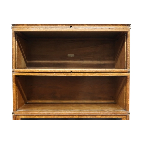 2051 - AN EARLY 20TH CENTURY OAK GLOBE WERNICKE SECTIONAL BOOKCASE with four glazed fall front section... 