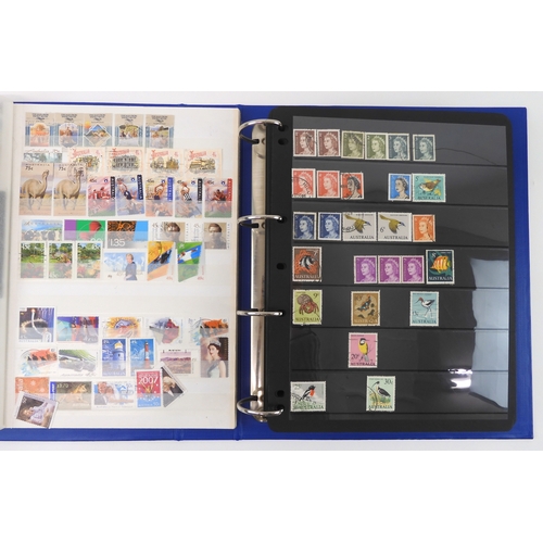 7021 - AUSTRALIA <br />A collection of new and used stamps in three albums and a stock book to include book...