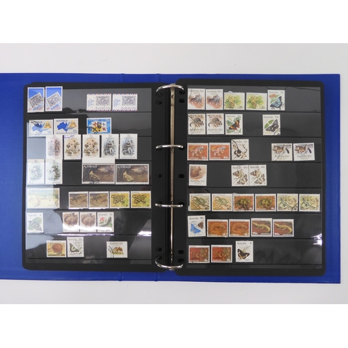 7021 - AUSTRALIA <br />A collection of new and used stamps in three albums and a stock book to include book...