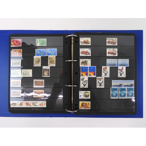 7021 - AUSTRALIA <br />A collection of new and used stamps in three albums and a stock book to include book...