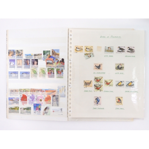 7021 - AUSTRALIA <br />A collection of new and used stamps in three albums and a stock book to include book...