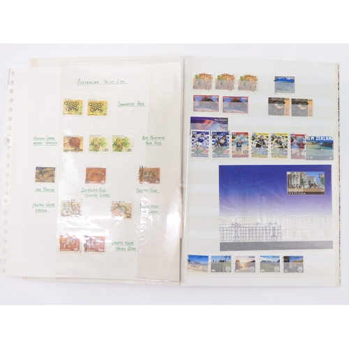 7021 - AUSTRALIA <br />A collection of new and used stamps in three albums and a stock book to include book...