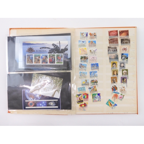 7021 - AUSTRALIA <br />A collection of new and used stamps in three albums and a stock book to include book...