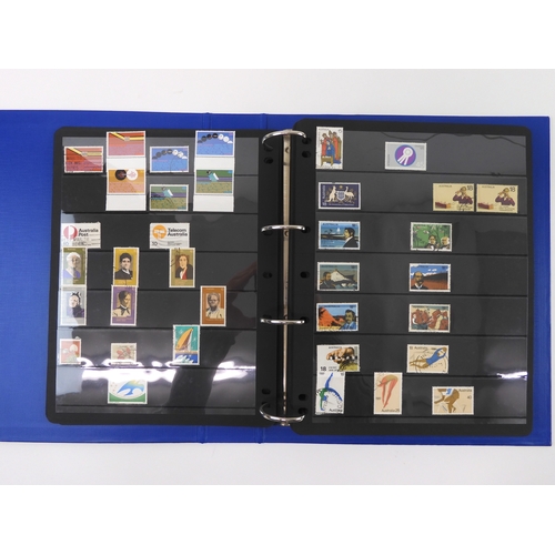 7021 - AUSTRALIA <br />A collection of new and used stamps in three albums and a stock book to include book...