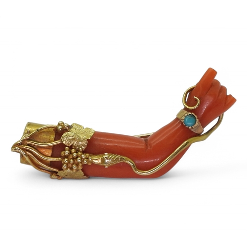 2787 - A SYMBOLIC CORAL BROOCHthe coral carved in the shape of an arm with two fingers extended in a symbol... 