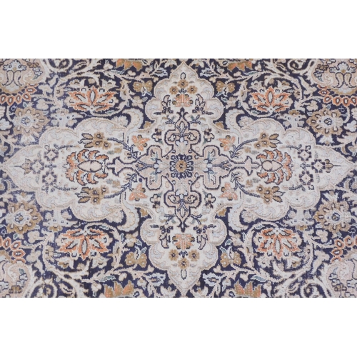 105 - A dark blue ground fine silk Kashmiri rug with cream central medallion and matching spandrels on flo... 