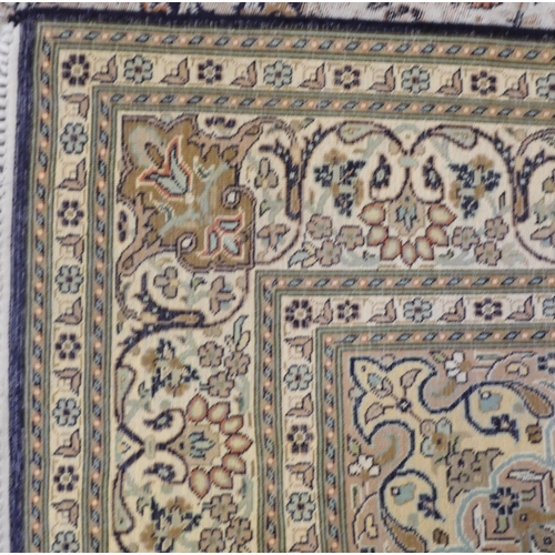 105 - A dark blue ground fine silk Kashmiri rug with cream central medallion and matching spandrels on flo... 