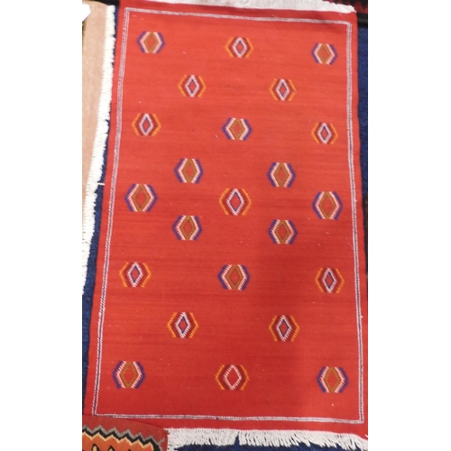 107 - A lot comprising a small red ground Kilim rug with geometric lozenge design, 108cm long x 64cm wide,... 