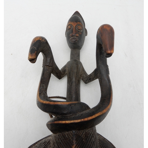 2277 - A SENOUFO MASKCarved and detailed with a figure holding two serpents above combed hair and scored fa... 