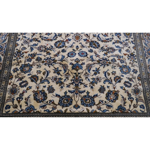 2123 - AN IVORY GROUND KESHAN FINE PILE WOOL RUG with all over floral/foliate design within multicolou... 