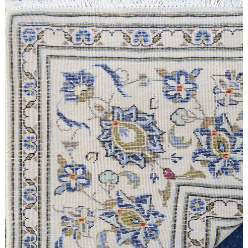 2125 - AN IVORY GROUND KASHAN FINE PILE WOOL RUGwith all over floral/foliate patterned ground within flower... 