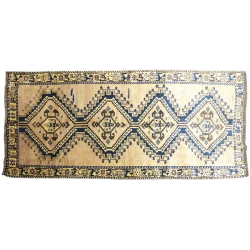 2127 - A BEIGE GROUND BALUCHI FINE PILE WOOL RUNNER with four dark geometric diamond shaped medallions... 