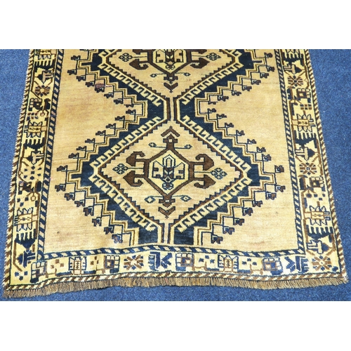 2127 - A BEIGE GROUND BALUCHI FINE PILE WOOL RUNNER with four dark geometric diamond shaped medallions... 