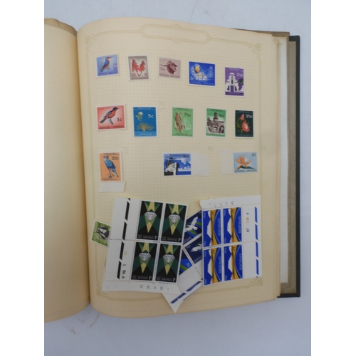 7045 - A worldwide stamp collection in four albums including 1 album of  GB with early phosphor sets, one a...