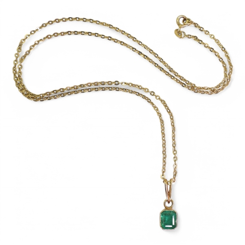 2750 - EMERALD PENDANTA bright yellow metal mounted emerald pendant. Set with a step cut emerald of estimat... 