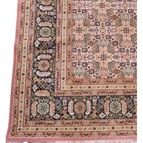 41 - A multicoloured geometric patterned ground Persian style rug within dark blue foliate patterned bord... 