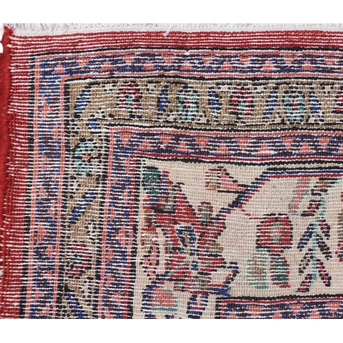 6 - A red ground Hamadan rug with cream and blue central medallion and matching spandrels on floral patt... 