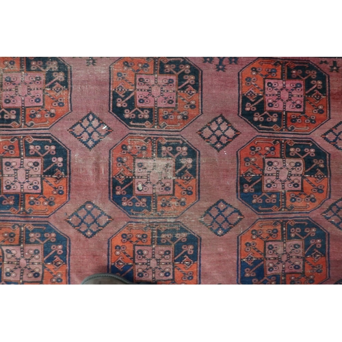 15 - A terracotta ground Afghan rug with all-over geometric lozenge patterned ground within geometric bor... 