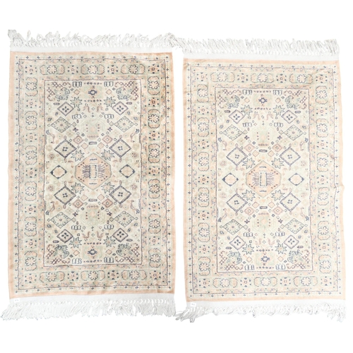 72 - A lot comprising a blue and red geometric patterned ground rug, pair of beige ground rugs and two fl... 