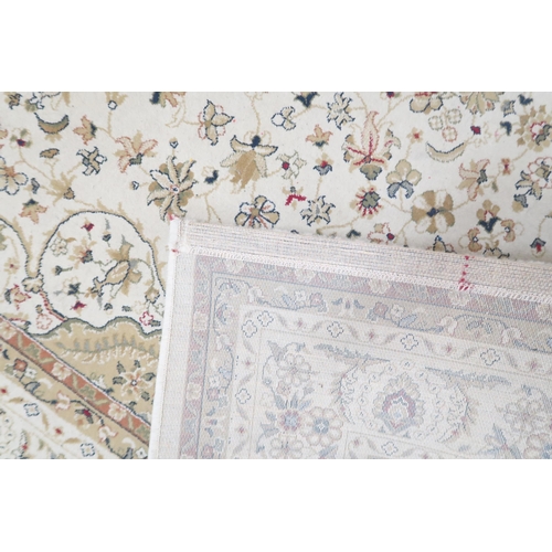 82 - A cream ground Tabriz style rug with sunburst central medallion and beige spandrels on floral patter... 