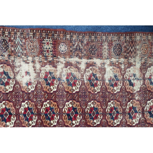 4 - A ochre ground antique Turkoman rug with all-over multicoloured lozenge patterned ground within mult... 